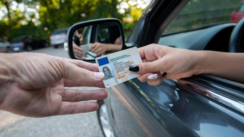 Teenager driver handing over her license
