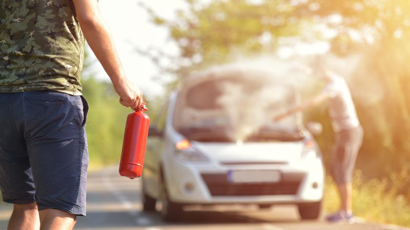 person with fire extinguisher for smoking car